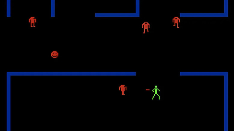 A green stick figure shoots at a red robot in a blue maze in Berzerk