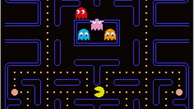 Colorful ghosts emerge from a cell as Pac-Man eats dots below them in Pac-Man