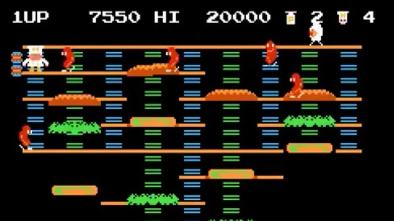 Peter Pepper climbs down a ladder while being chased by sausages in BurgerTime