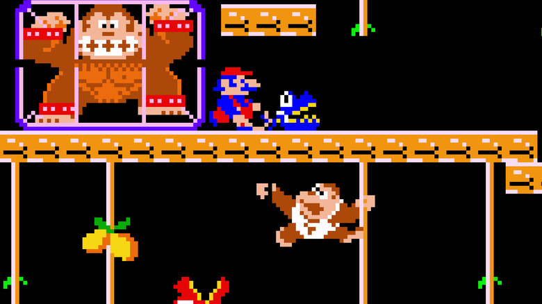 Donkey Kong Jr. climbs up vines under Mario and a caged Donkey Kong in Donkey Kong Jr.