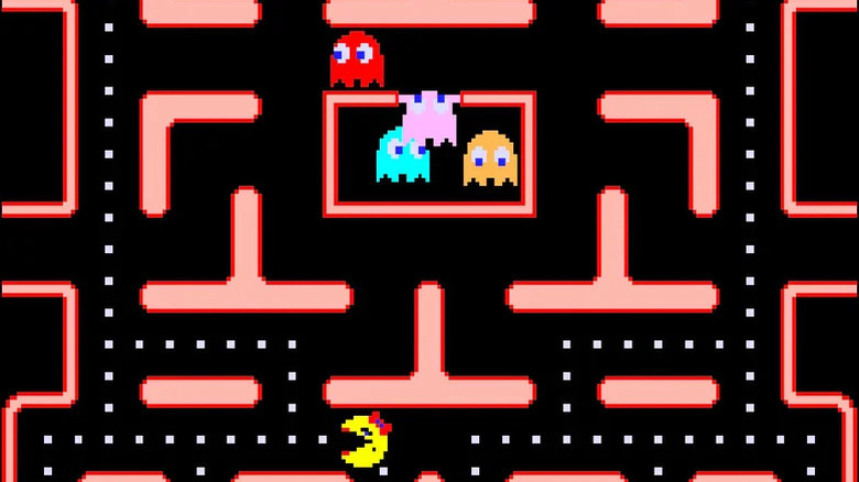 Ms. Pac-Man eats dots as ghosts emerge from a cell above her in Ms. Pac-Man
