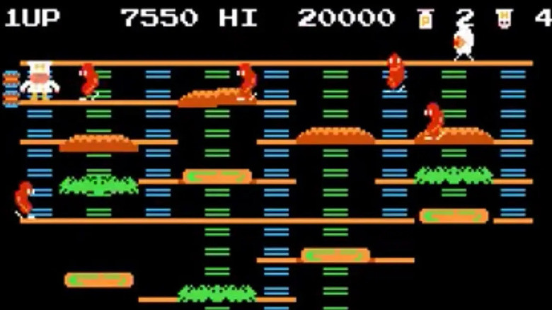 Peter Pepper climbs down a ladder as he's surrounded by advancing sausages in BurgerTime