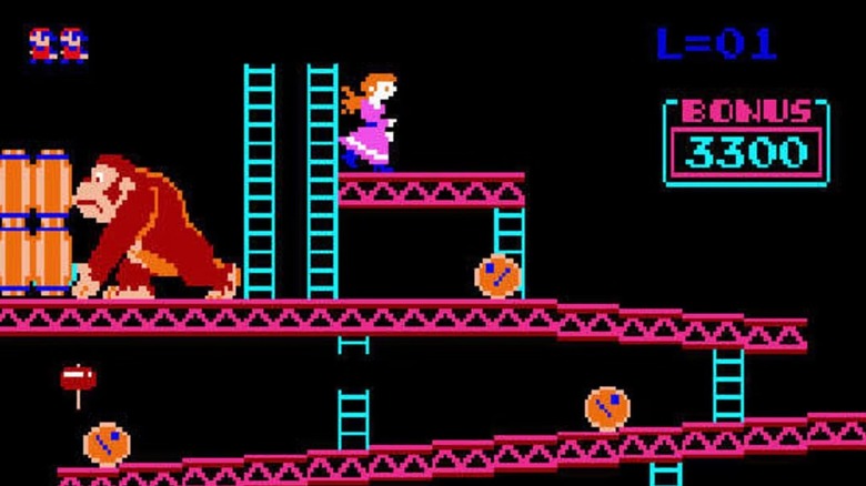 Donkey Kong grabs a barrel as Pauline stands on a platform next to him in Donkey Kong
