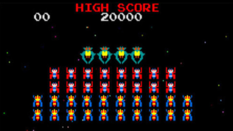 A group of colorful bug-designed fighters organized in rows float in space in Galaga
