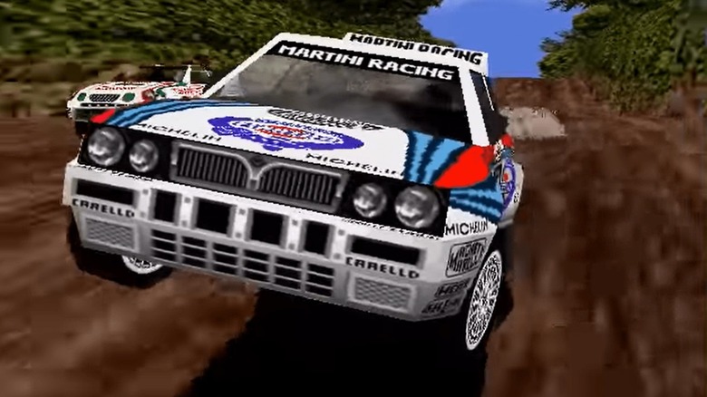 A rally car leaps over a dirt road in Sega Rally Championship