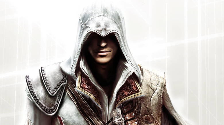 Ezio Auditore smiles under his white hood on the cover art for Assassin's Creed II