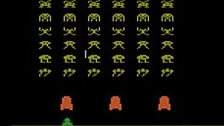 A green spaceship faces descending yellow aliens in Space Invaders
