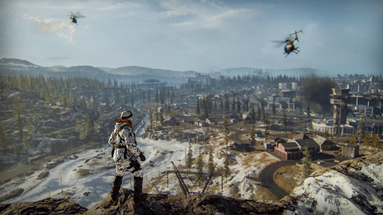 A soldier watches two helicopters flying over a forest in Call of Duty: Warzone
