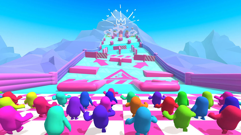 A group of colored bean people run towards an obstacle course in Fall Guys