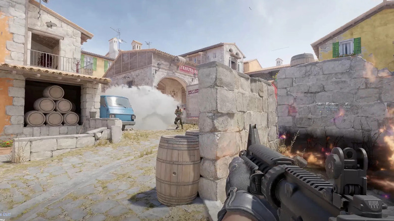 A player advances on an enemy emerging from a smoke grenade in Counter-Strike 2