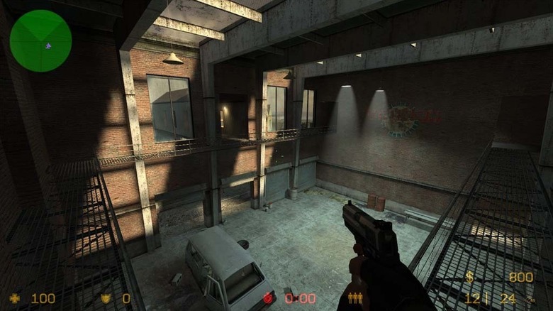 A player holding a pistol surveys a garage in Counter-Strike: Source