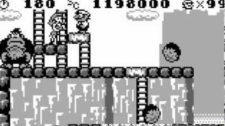 Mario stands on a platform next to Pauline while Donkey Kong holds a boulder in Donkey Kong (1994)