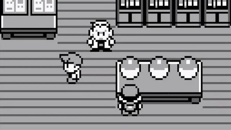 The Pokémon trainer approaches a table with three Pokéballs as Professor Oak watches in Pokémon Red