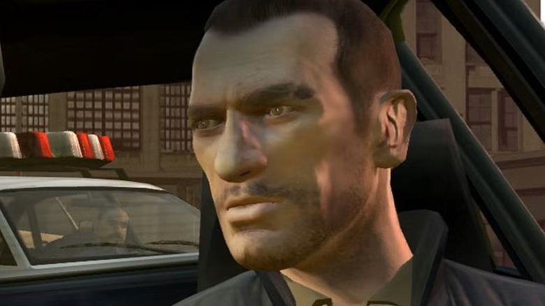 Niko looks at the police car behind him in a screenshot from Grand Theft Auto 4 (2008)