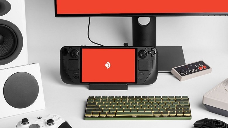 A Steam Deck OLED sits between a monitor and screen
