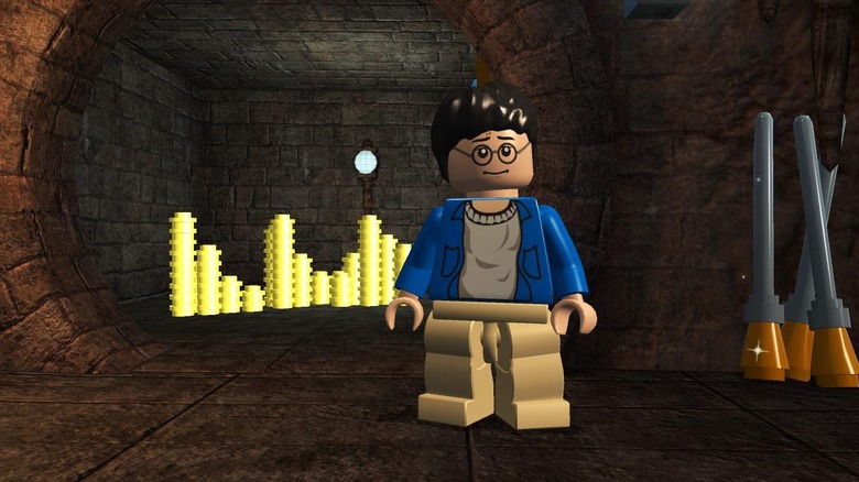 Harry Potter stands in a vault with gold and broomsticks in LEGO Harry Potter: Years 1-4