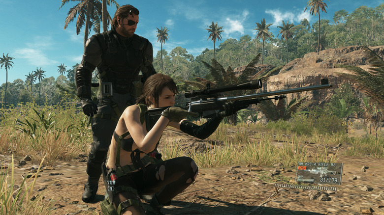 Venom Snake stands behind Quiet as she takes aim in Metal Gear Solid V: The Phantom Pain