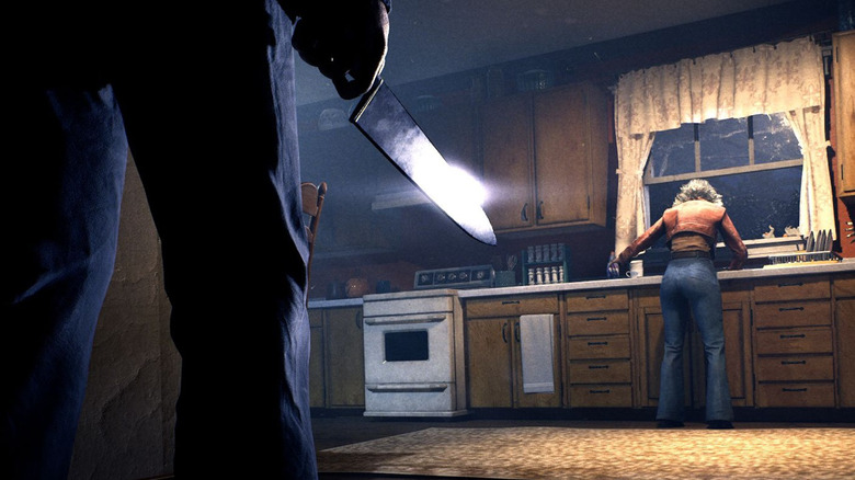 Michael Myers holds a knife while standing behind a woman in a kitchen in Halloween: The Game
