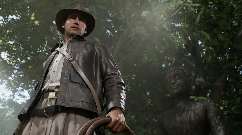 Indiana Jones stands in a rainforest holding his whip in Indiana Jones and the Great Circle