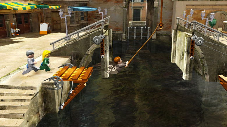 Indiana Jones swings across a Venetian canal as Elsa Schneider and Marcus Brody follow in LEGO Indiana Jones: The Original Adventures