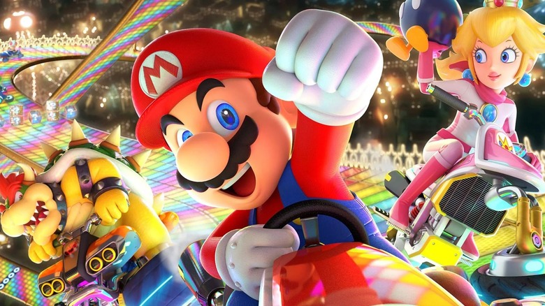 Mario pumping his fist on Rainbow Road with Peach and Bowser behind him in Mario Kart 8 Deluxe artwork