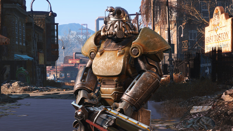 An armored soldier holds a futuristic weapon the street in Fallout 4