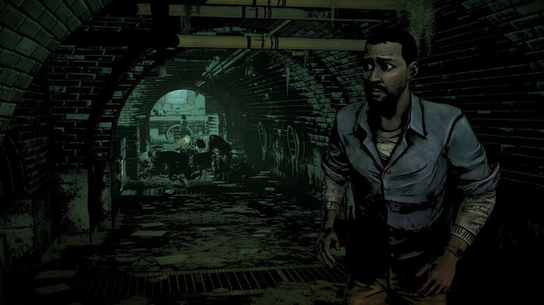 Lee Everett steaks past zombies in a sewer in The Walking Dead