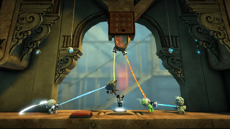 A group of Sackboys pull colored threads in LittleBigPlanet 2