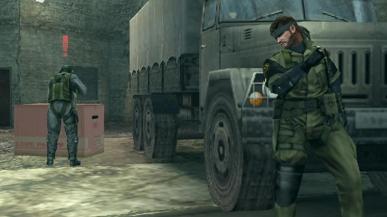 Big Boss hides in front of a truck while a soldier is distracted by a box in "Metal Gear Solid: Peace Walker" (2010)