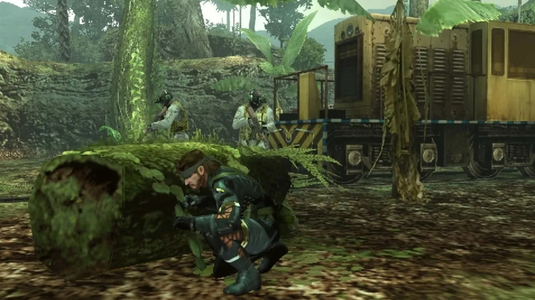 Big Boss hides behind a log near two soldiers in "Metal Gear Solid: Peace Walker" (2010)