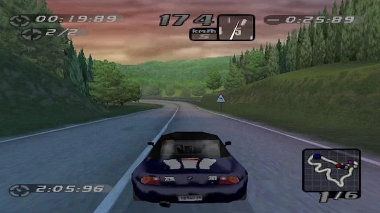 A car drives down a forested road in Need for Speed: High Stakes