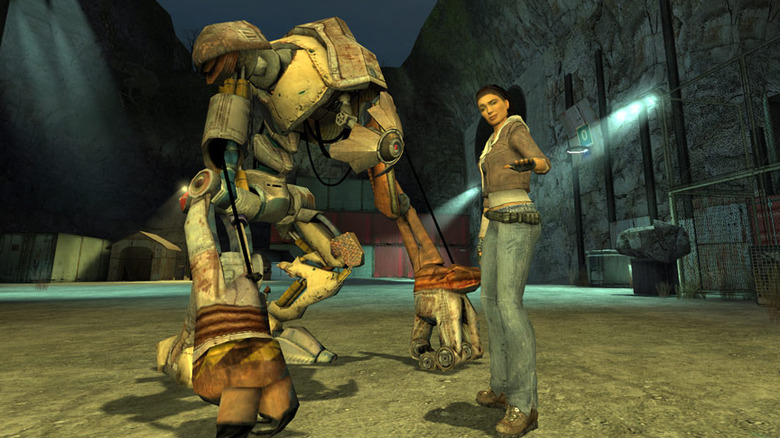 Alyx Vance motions to the player while standing next to a robot in "Half-Life 2" (2004)