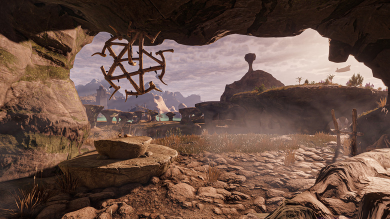 The player peers out from a cave in Enshrouded