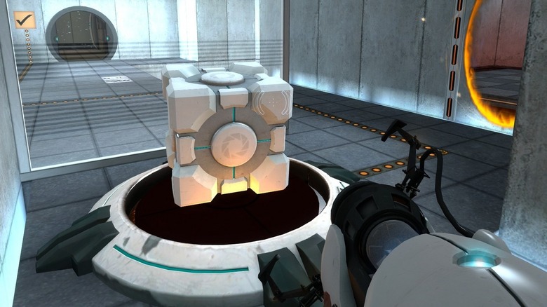 Chell approaches a cube with a portal gun in Portal (2007)