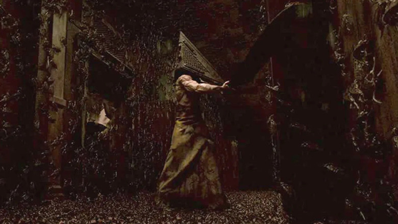 Pyramid Head swings a large sword through a bug-infested hallway in Silent Hill