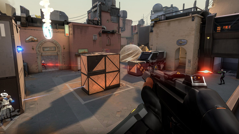 A player holds a shotgun while surveying a gunfight in a courtyard in Valorant