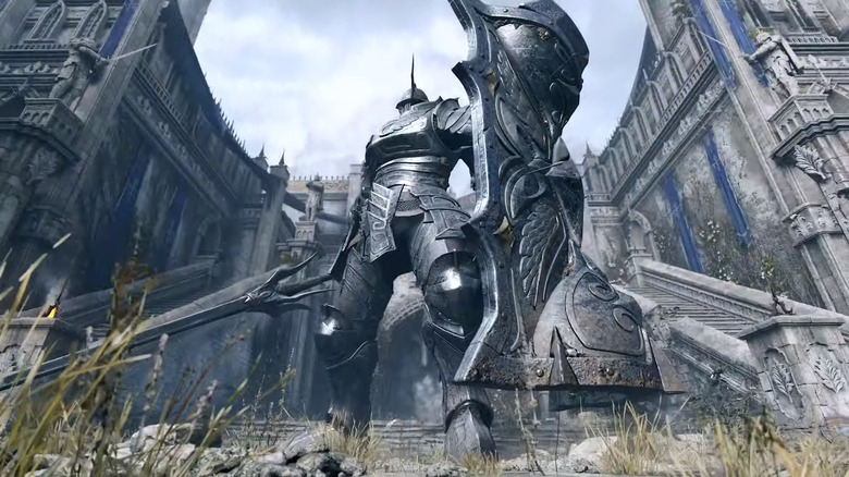 A armored knight stands before a castle in Demon's Souls (2020)