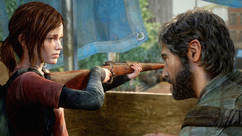 Ellie looks at Joel Miller while holding a rifle in The Last of Us