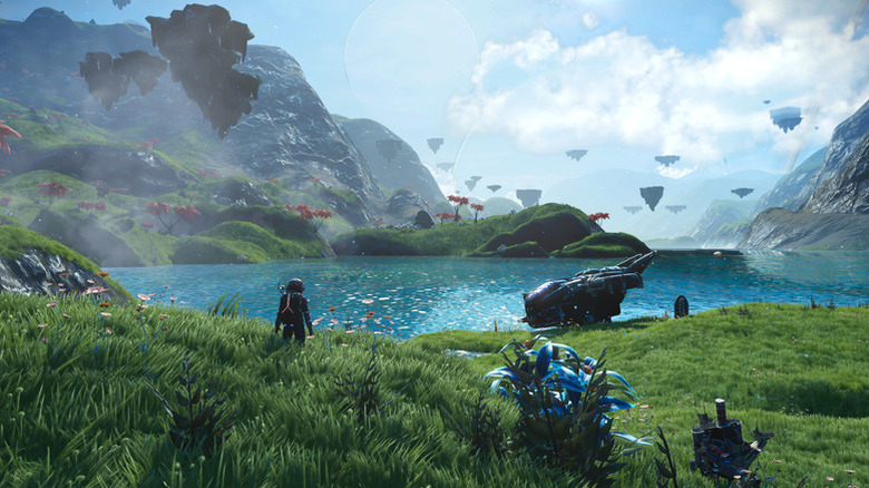 A player character surveys a large lake from a grassy hill in No Man's Sky