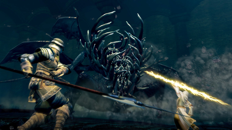 Two soldiers fight a grotesque monster in Dark Souls