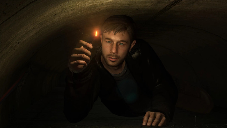 Ethan Mars crawls through a tunnel with a lit match in Heavy Rain
