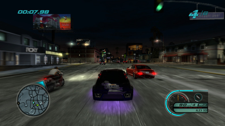 Two cars racing a motorcycle at night in Midnight Club: Los Angeles