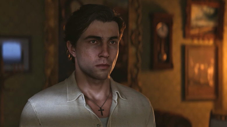 Enzo Favara stands solemnly in a dimly lit living room in "Mafia: The Old Country" (2025)