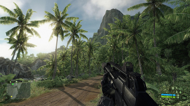 A player character holding an assault rifle walks through a jungle in Crysis