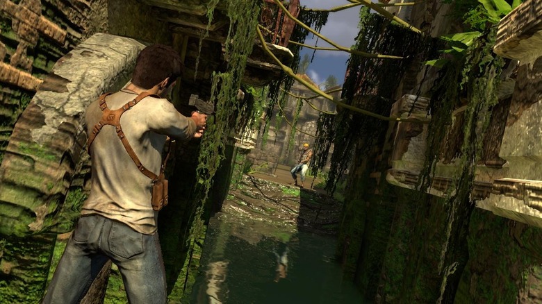 Nathan Drake aims a pistol at an enemy in ancient ruins in Uncharted: Drake's Fortune