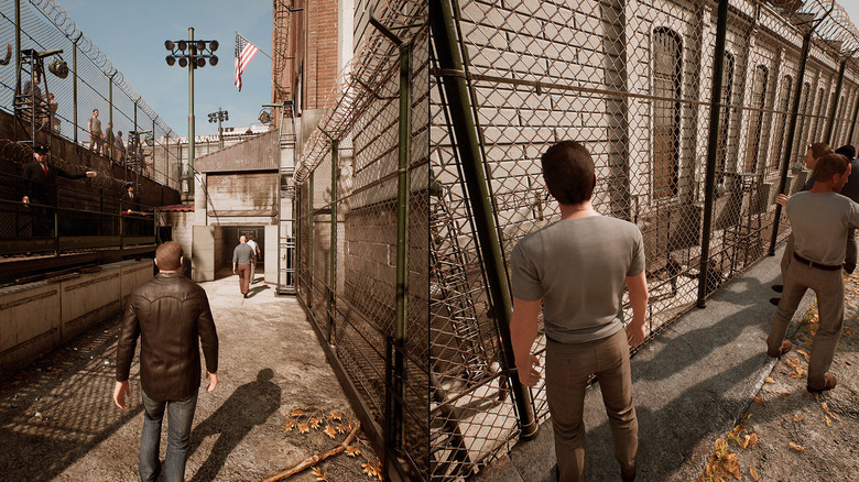 Vincent Moretti and Leo Caruso stand in different parts of a prison yard in A Way Out