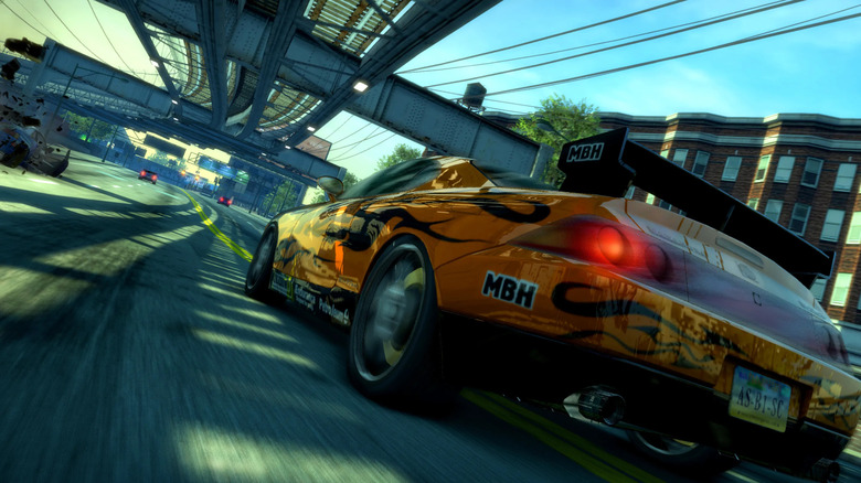 A sports car drives under an elevated train track in Burnout Paradise