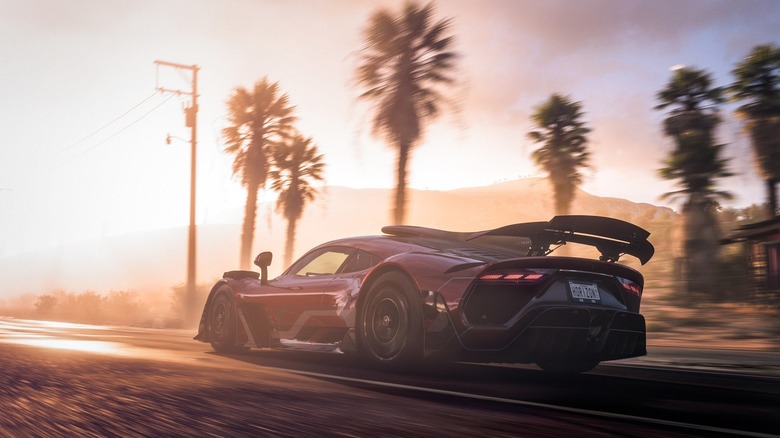 A sports race speeds down a road next to palm trees in Forza Horizon 5