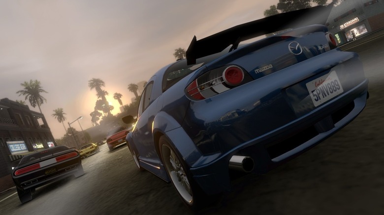 A group of sports cars race down a street during sunset in Midnight Club: Los Angeles