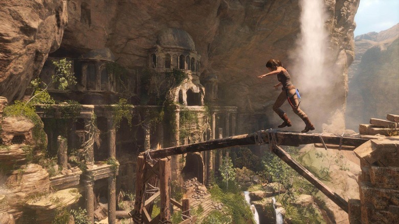 Lara Croft balancing on a beam near a temple in Rise of the Tomb Raider